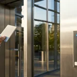 Employee using a key card on an office door access control system.